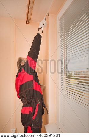 Older Man Working In Empty Apartment Repairing Holes In Walls