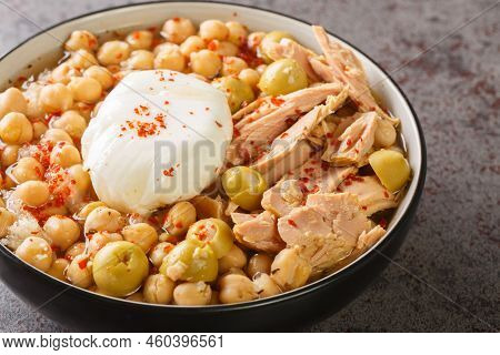 Chickpeas In Broth Served With Canned Tuna, Olives And Poached Egg Close-up In A Bowl On The Table. 