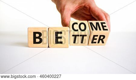 Become Better Symbol. Businessman Turns Wooden Cubes And Changes The Concept Word Better To Become. 