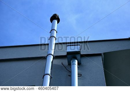 Industrial White Building With Sheet Metal Facade Of Repeating Rectangle Paneling. On Wall Are Two S
