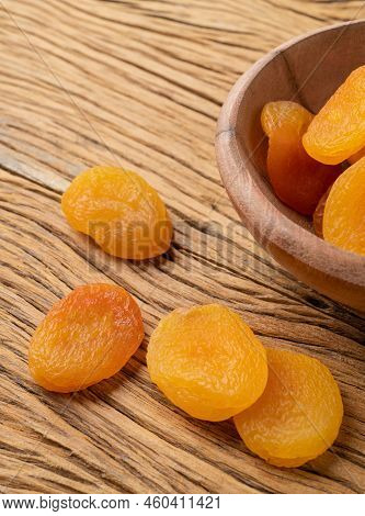 Dried Apricots On A Bowl Over Wooden Table.