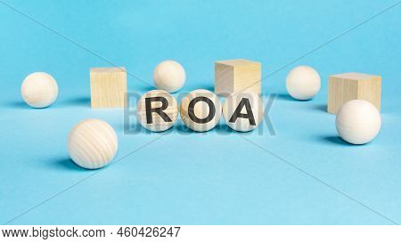 Concept Text 'roa' On Wooden Spheras On A Beautiful Blue Background. Business Concept. Copy Space. R
