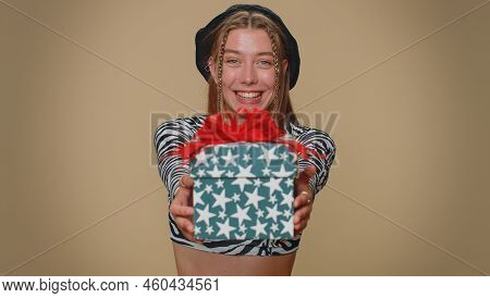 Positive Smiling Lovely Pretty Young Woman Presenting Birthday Gift Box Stretches Out Hands, Offer W