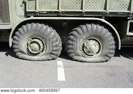 A Punctured And Flat Tire Of Military Equipment Of The Armored Personnel Carrier. Military Conflict,