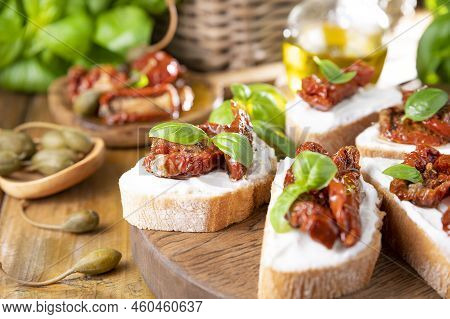 Bruschetta With Sun-dried Tomatoes, Cheese, Basil And Capers. Traditional Appetizer For Aperitivo In