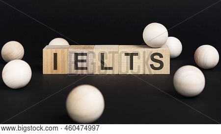 Business And Economy Concept. On A Black Surface And Wooden Cubes With The Inscription - Ielts - Int