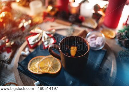 Mulled Red Wine Gluhwine In Cup With Orange, Christmas Decor Table With Candles