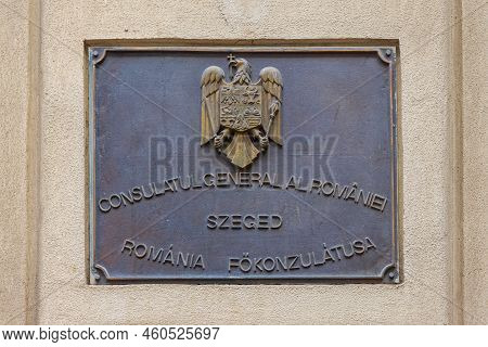 Szeged, Hungary - July 30, 2022: Dual Language Bronze Plaque With Coat Of Arms At Romania Consulate 