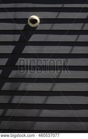 Parallel Horizontal Shadows Om The Grey Wall With A White Vent