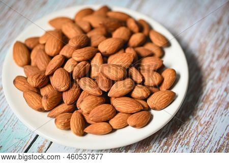 Almonds Nuts On White Palte, Delicious Sweet Almonds On The Wooden Table Background, Roasted Almond 