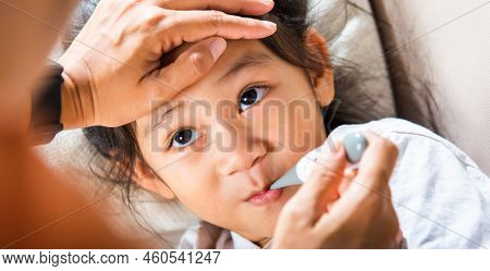 Sick Kid. Mother Checking Temperature Of Her Sick Daughter With Thermometer In Mouth, Child Laying I
