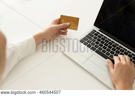 Cropped Hands Of Mid Adult Caucasian Woman Doing Online Shopping Over Credit Card And Laptop On Whit