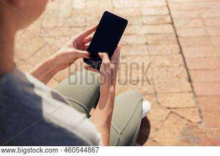 High Angle Low Section Of Young Athletic Woman Messaging Over Mobile Phone While Sitting On Seat In 
