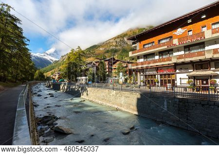 Zermatt, Switzerland - October 7, 2019: Town Street View In Famous Swiss Alps Ski Resort, River, Mat