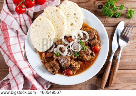 Beef Goulash And Dumplings (knedliky) On Wooden Table From Czech Republic