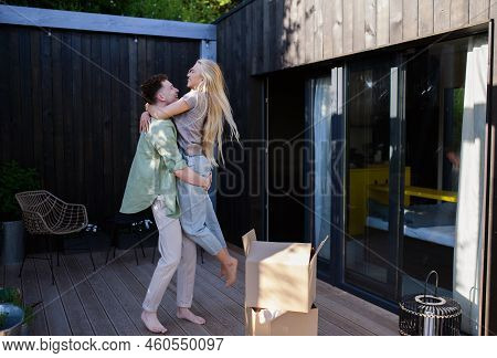 Cheerful Young Couple Moving In Their New Tiny House In Woods. Conception Of Moving And Sustainable 