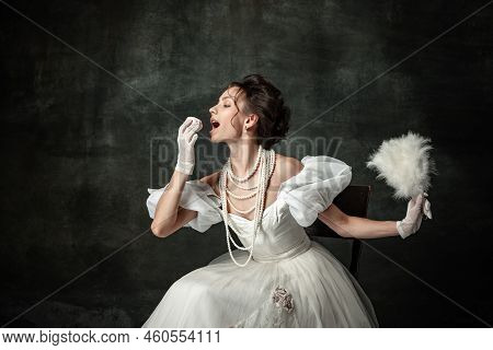 Enjoyment. Young Adorable Girl In Image Of Medieval Person Or Viscountess Tasting Sweets Isolated On