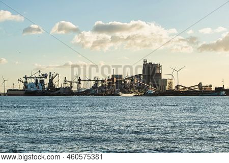 Rotterdam, Netherlands - November 22 2021 : Iron Ore Is Being Unloaded By Huge Cranes In Het Industr