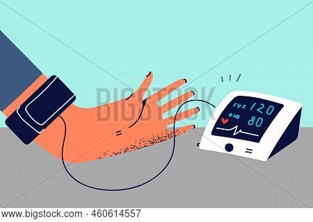 Close-up Of Person Measuring Pressure On Blood Pressure Monitor. Patient Doing Checkup With Electron