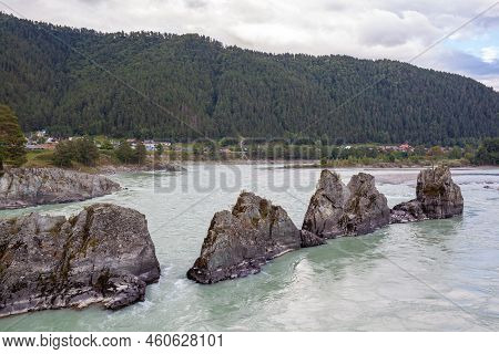 A Fast-flowing Wide And Full-flowing Mountain River. Large Rocks Stick Out Of The Water. Big Mountai