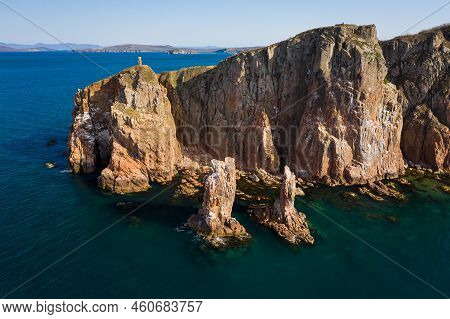 Beautiful High Vertical Cliffs On The Sea Coast At Dawn. Two Sea Stacks, Vertical Columns In The Sea