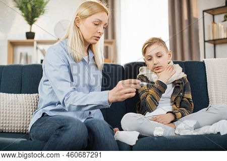 Family, Healthcare, Flu And Cold Concept. Stay At Home. Mother Taking Care Of Her Cute Sick Teen Boy