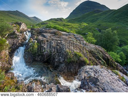 On Mid Summer Late Afternoon,water From Nearby Mountains Pours Down Over Textuted Rocks And Boulders