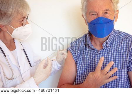 Doctor Giving Injection To Senior Caucasian Man, Old Retired Receiving Booster Of Covid 19 Vaccine, 