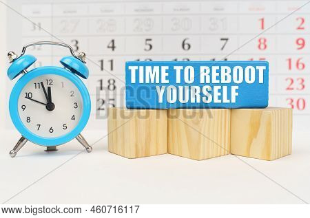 Time Concept. Against The Background Of The Calendar Is An Alarm Clock, Cubes And A Blue Block With 