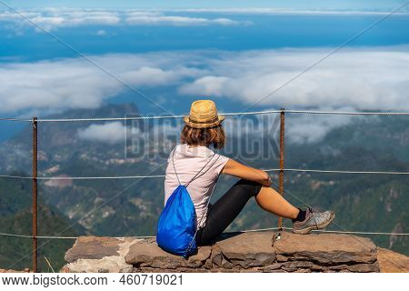 A Young Woman Sitting At The Miradouro Do Juncal On Pico Do Arieiro, Madeira. Portugal