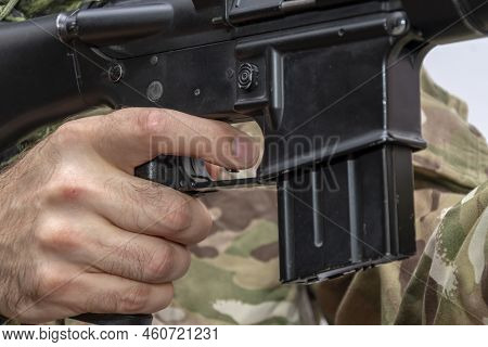 A Military Man Holds His Finger On The Trigger Of An American Automatic Rifle.a Military Man Holds H