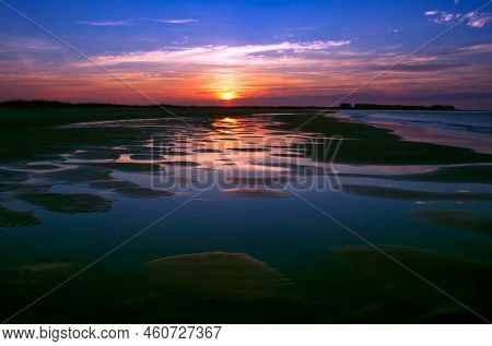Sun Rises Over The Atlantic Ocean And The Tidal Pools Along The Shore At Holden Beach, North Carolin
