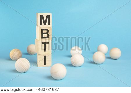 A Pyramid Of Wooden Cubes With The Word Mbti And Wooden Balls Around On A Bright Blue Background, Co
