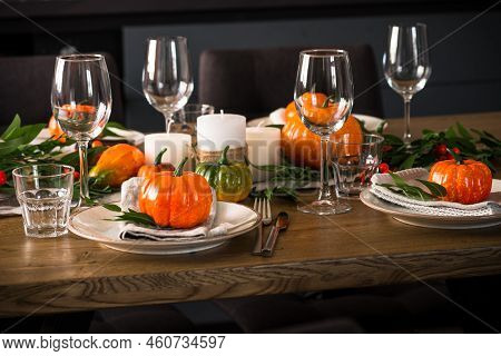 Autumn Table Setting With Plate, Glass, Cutlery And Autumn Decor At Wooden Table. Thanksgiving Food 