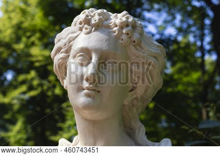 Close-up Of Woman's Head Made Of White Marble. Old Statue Of Sensual Young Girl Bareheaded With Rain