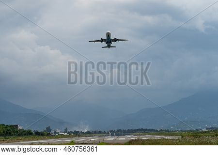 Airplane Taking Off From The Airport, Mountains On Background. Passenger Plane Fly Up Over Take-off 