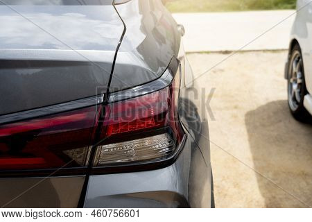 Rear Side Of Car Gray Color With Tail Lights. Parking On The Soid Beside Of The Road At Day.