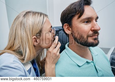 Ent Doctor Checking Adult Mans Ear Using Otoscope Or Auriscope At Medical Center