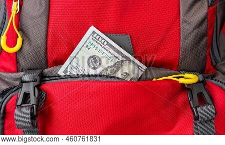 Money Peeking Out Of A Backpack Pocket. A Dollar Bill Falls Out Of A Backpack Pocket. Pickpocket Lur
