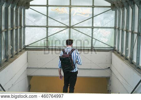 Man With A Backpack Going Downstairs To An Underpass