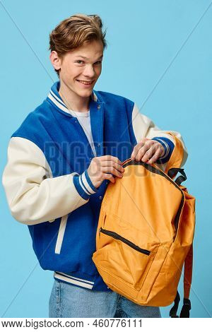 A Handsome, Charming Student Guy In A Stylish Blue Bomber Jacket Laughs Joyfully Looking At The Came