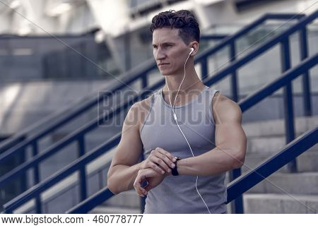 Training And Lifestyle Concept. Runner With Heart Rate Monitor Sports Smart Watch. Looking At Watch.