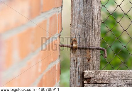 Iron Rusty Cheek On A Wooden Door.detail Of An Old Wooden Door With A Rusty Latch In The Village Yar