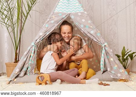 Image Of Happy Optimistic Family, Mother With Her Little Daughters Sitting In Peetee Tent Together A