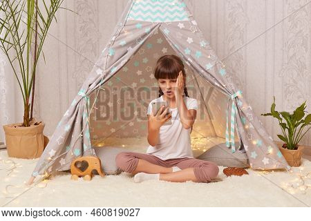 Image Of Astonished Shocked Little Girl With Braids Wearing White T Shirt Posing In Peetee Tent, Chi
