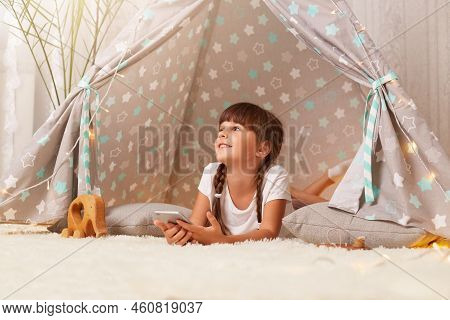 Smiling Dreaming Cute Little Girl With Braids Wearing White T Shirt Posing In Peetee Tent With Smart