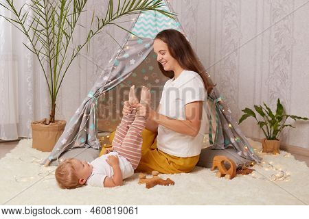 Portrait Of Happy Smiling Delighted Mother Wearing White T Shirt Sitting In Peetee Tent And Having F