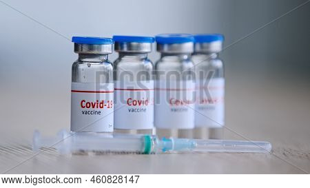 Close-up Four Bottles With Covid-19 Vaccine Remedy For Illness Epidemic Medicine Cure Drug Stands On