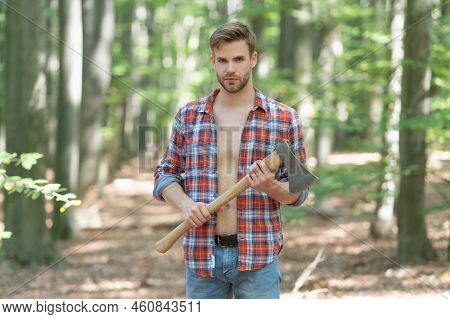 Unshaven Axeman Man In Lumberjack Style Standing With Axe Forest Background