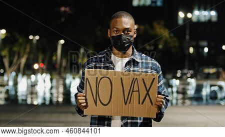 Portrait Angry African American Man In Face Mask Stands In City At Night Evening Holding Sign Banner